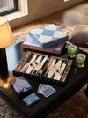 The Game Table at MA VIE: lacquered backgammon mid-game, Reverra playing cards and chess set on a black coffee table