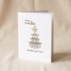 Champagne Tower letterpress greeting card by Dahlia Press standing on a natural cotton backdrop