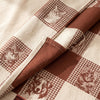 Truffes jacquard damask folded back to show the checkerboard and animal portraits woven on both faces