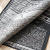 A Vol d'Oiseau Paris jacquard damask folded back to show the same aerial map of Paris woven on the reverse in the opposite colourway