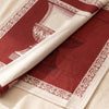 Médicis jacquard damask folded back to show the same classical urn woven on the reverse in the opposite colourway