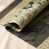 Sulawesi jacquard damask folded back to show the same tropical foliage woven on the reverse in the opposite colourway