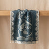 Curiosités Animales jacquard tea towel draped over an oak edge, showing how the cloth hangs