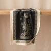 Curiosités Florales jacquard tea towel draped over an oak edge, showing how the cloth hangs