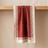 Médicis jacquard tea towel draped over an oak edge, showing how the cloth hangs