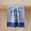 Promenade Impériale jacquard tea towel draped over an oak edge, showing how the cloth hangs