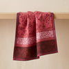 Romance jacquard tea towel draped over an oak edge, showing how the cloth hangs
