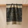 Sulawesi jacquard tea towel draped over an oak edge, showing how the cloth hangs