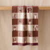 Truffes jacquard tea towel draped over an oak edge, showing how the cloth hangs