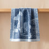 Versailles jacquard tea towel draped over an oak edge, showing how the cloth hangs