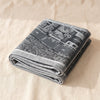 A Vol d'Oiseau Paris jacquard tea towel folded, showing the weight and thickness of the cloth