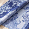 Promenade Impériale napkin turned back to show the peonies and peacock woven on both faces