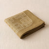 Hôtel Particulier linen napkin folded, showing the crisp linen hand and the weight of the cloth