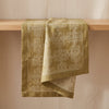 Hôtel Particulier linen runner draped over an oak edge, showing the crisper fall of linen