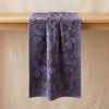 Sulawesi runner in Terre Indigo draped over an oak edge, showing how the cloth hangs
