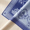 Promenade Impériale tablecloth folded back to show the reverse, the Lapis jacquard swapping ground and drawing