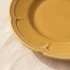 Close detail of the Dijon yellow dessert plate rim, its lobed edge and raised moulding