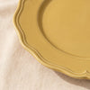 Close detail of the Dijon yellow dinner plate rim, its lobed edge and raised moulding