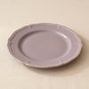 Lavender stoneware dinner plate at a low angle, showing its moulded edge and profile