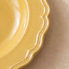 Close detail of the Dijon yellow soup plate rim, its lobed edge and raised moulding