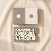 Faux leather domino set by Printworks, lid and open tray of ivory dominoes on the MA VIE cotton backdrop