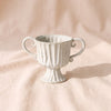 Fluted Loving-Cup Urn by Accent Decor, 12.5 inches wide handle to handle, speckled ivory reactive glaze on a pedestal foot