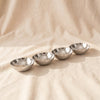 Four-Well Nut Dish in polished nickel, four oval wells in a row, on natural cotton