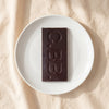 Casa Bosques date caramel dark chocolate bar unwrapped on a white plate