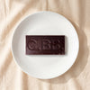 Casa Bosques Heirloom Cacao Nibs dark chocolate bar unwrapped on a white plate