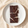 Casa Bosques preserved oranges dark chocolate bar broken on a white plate