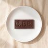 Casa Bosques pink peppercorn dark chocolate bar unwrapped on a white plate