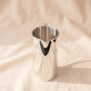 Santana silver-plated jug turned to show the pouring lip, on MA VIE cotton