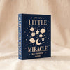 Little Miracle photo album by Printworks standing upright showing the front cover and spine, on MA VIE cotton