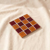 Glass tile coaster in The Old Day, oxblood and burnt amber checkerboard, by Subtle Art Studios