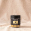 Lakrids B Passionfruit white chocolate-coated licorice in its black tub, by Lakrids by Bülow