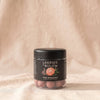 Lakrids Pink Pineapple white chocolate-coated licorice in its black tub, by Lakrids by Bülow