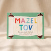 Mazel Torah Card by Mr. Boddington's Studio on a natural cotton backdrop