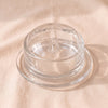 Bee Butter Dish with its domed lid in clear pressed glass by La Rochere, on a natural cotton backdrop