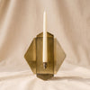Quatrefold Candle Sconce with a taper candle, on a natural cotton backdrop