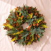 Fresh Magnolia Wreath in High Point Tapestry, 22 inch, with blue and yellow conifer, on a natural cotton backdrop