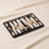 Lacquered backgammon set in black by Printworks on a natural cotton backdrop