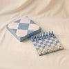 Reverra leather chess set by Printworks open with pieces set at an angle on a natural cotton backdrop