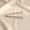 Avenir ice tongs in polished steel by Zodax on a natural cotton backdrop