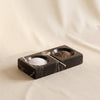 Marble salt and pepper dish in black by Zodax filled with salt and pepper on a natural cotton backdrop